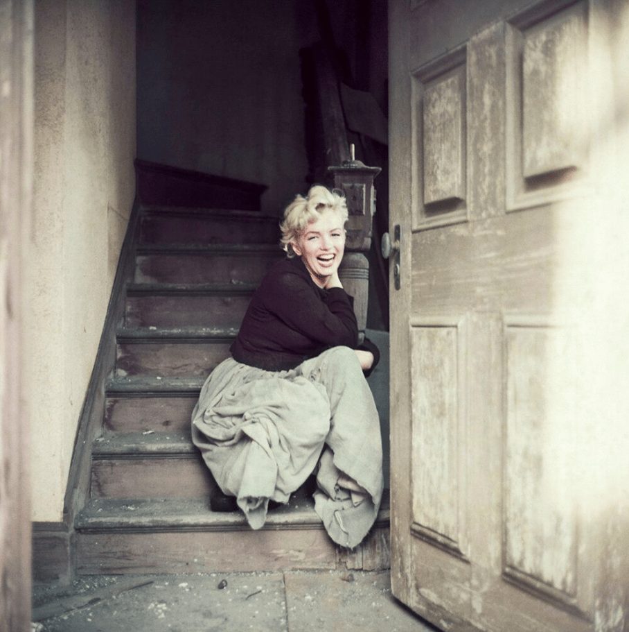 L'actrice Marilyn Monroe sans maquillage assise sur des marches
