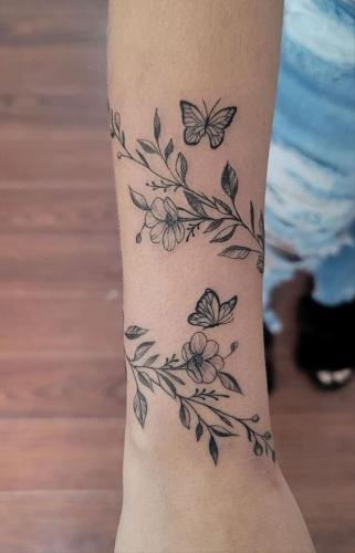 Idée tatouage femme papillon avec fleurs